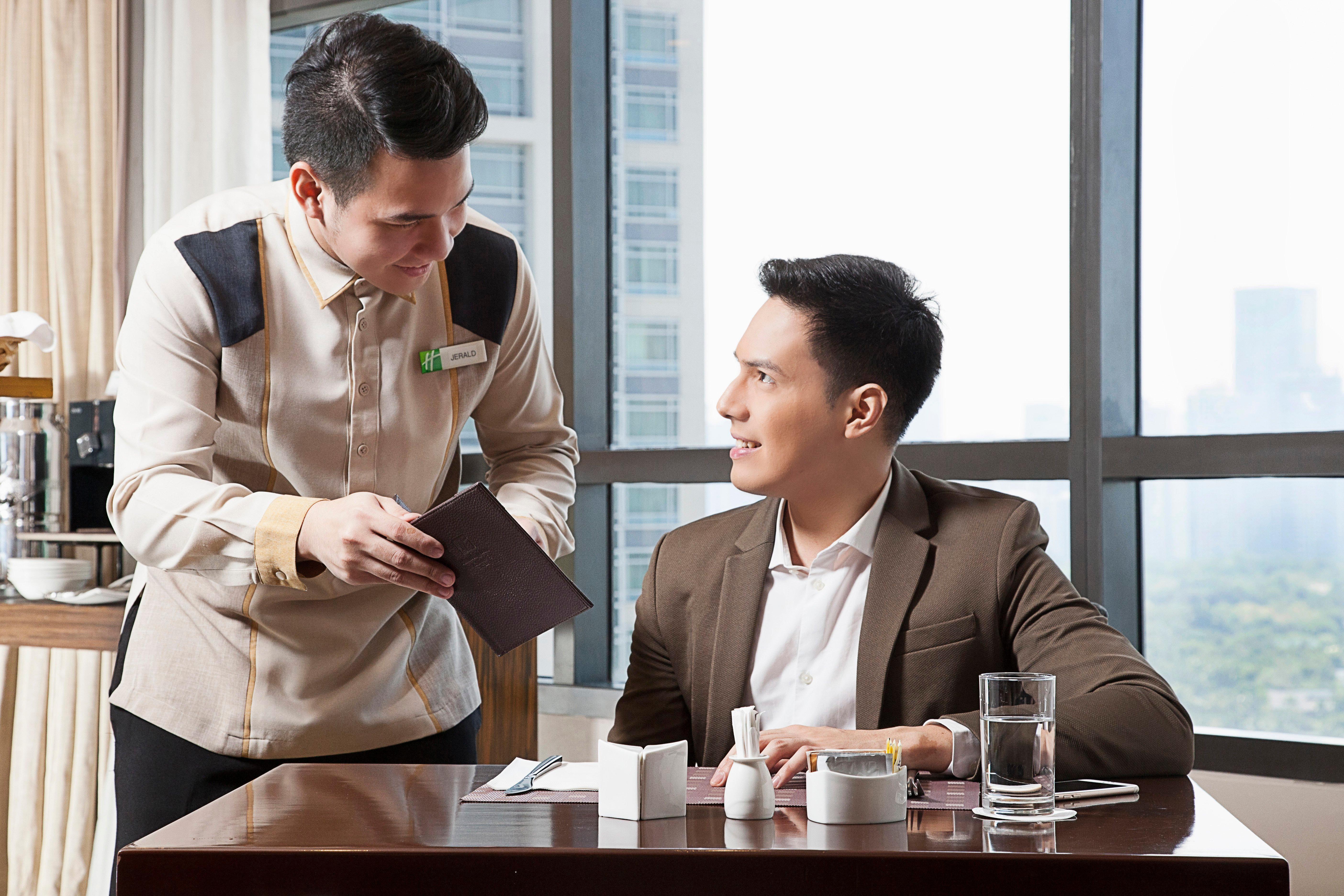 Holiday Inn & Suites Makati By Ihg Макати Экстерьер фото A butler serving a guest